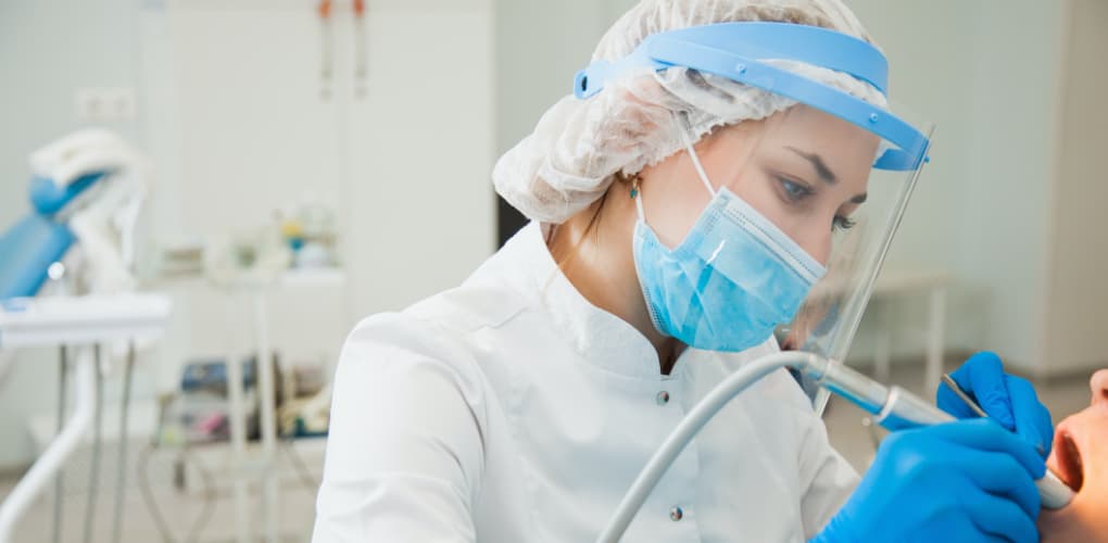 A dentist performs a cleaning on a difficult dental patient in a dental office.