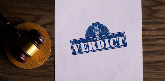 a gavel and a paper reading the word "verdict"