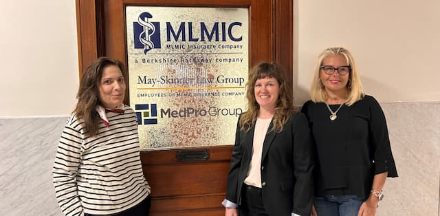 MLMIC employees standing in front of office door depicting April 2024 Events for New York State Physicians
