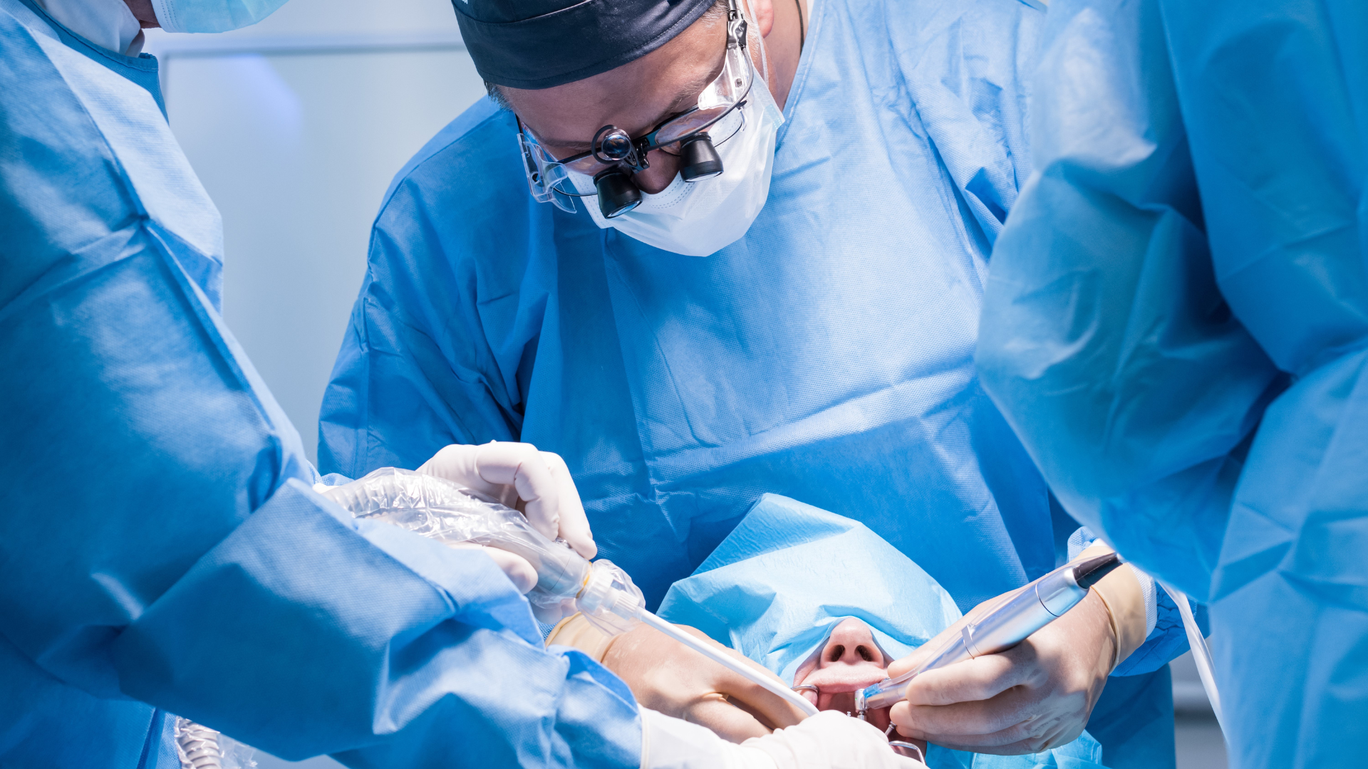 Dentists performing a surgical dental procedure in an operating room.