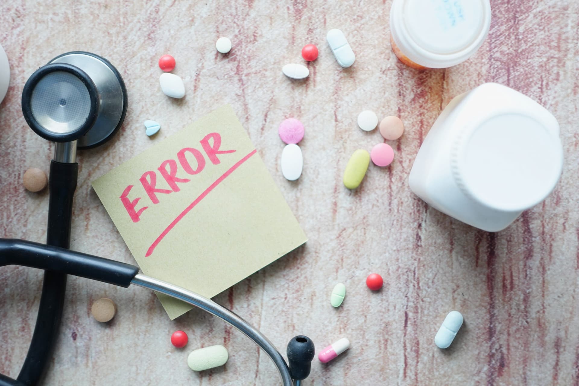 medical error text on a paper with pills and stethoscope on table .