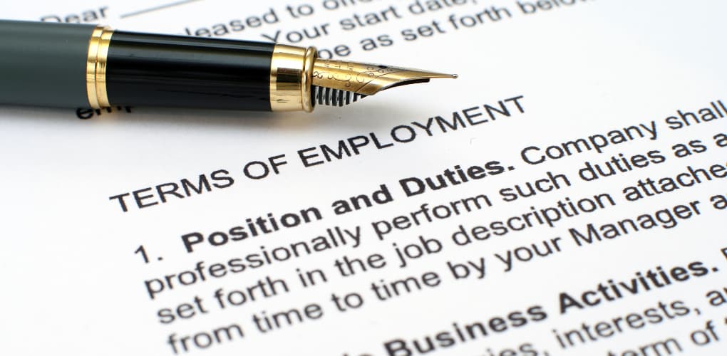 Image of an employment contract first page with an open pen