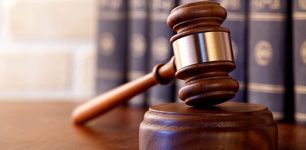 A gavel rests on a table in a court room