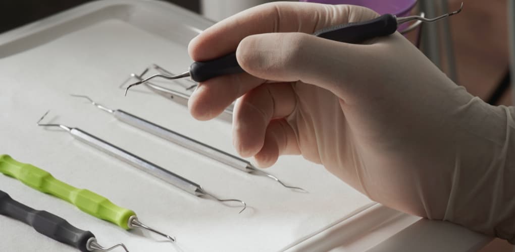 Dentist holds various dental tools, image for blog on oral cancer case study