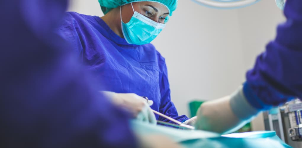 Several dentists perform procedures on a patient; image for a blog on HIV confidentiality in dentistry