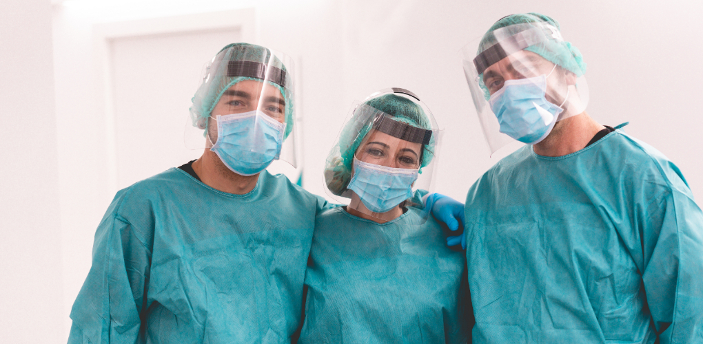 Lessons from covid19 - Three dentists in PPE stand together.