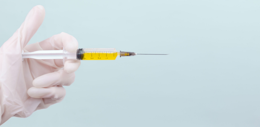 A provider holds up a needle of fluid in the image for this blog on botox in dentistry.