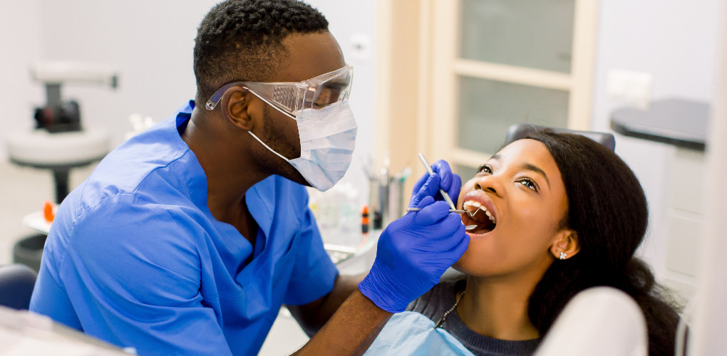 A dentist checks a patient for caries lesions